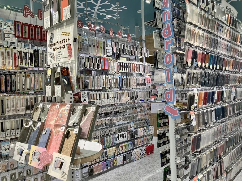 スマートフォンケースとアクセサリーが並ぶ店内の商品陳列棚